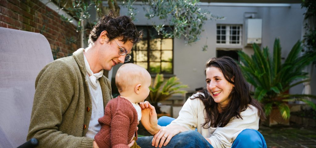 Picture with parents laughing with their baby in a garden
