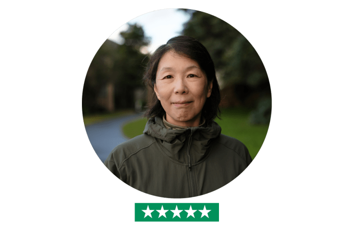 Woman looking in camera outdoors - five star rating