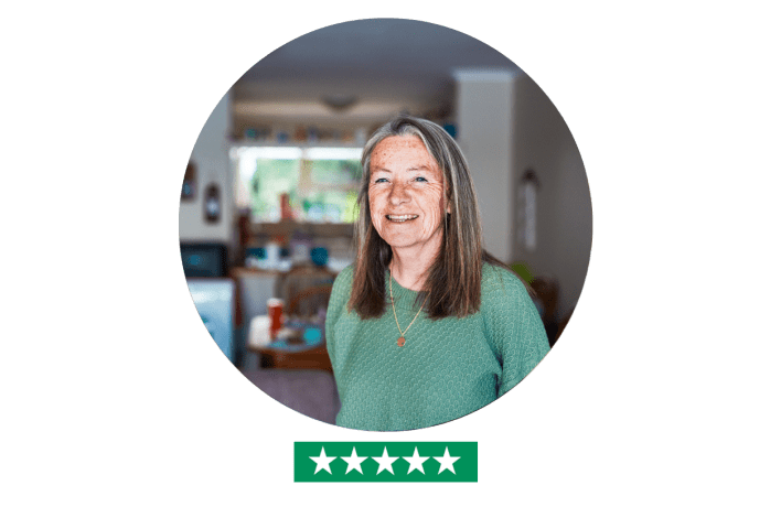 Woman in home looking into camera - five star rating