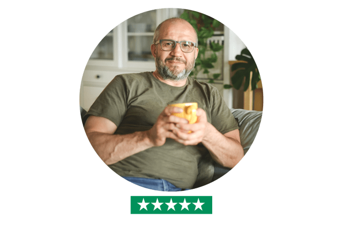Man in home with cup in hand, looking into camera - five star rating
